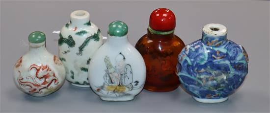 Four 19th century porcelain snuff bottles and an inside painted amber glass snuff bottle